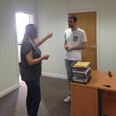 Two members of the Halo Housing team talking in an office